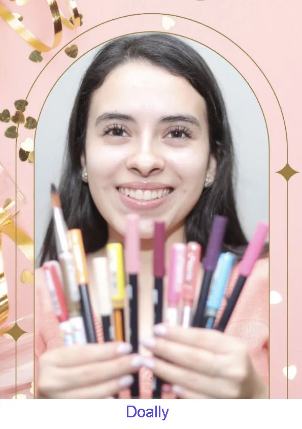 Doally Melgar smiling and holding a fan of colorful calligraphy pens.